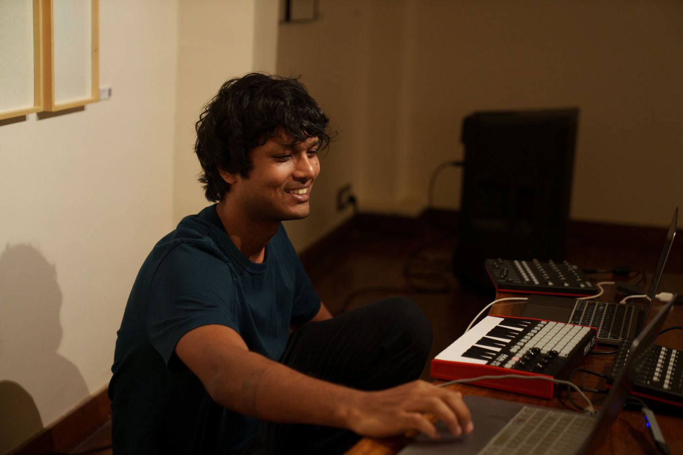 Harsh smiling at a synth keyboard.