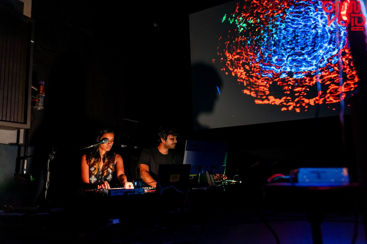 Sahitya and Harsh performing under a projected cymatics pattern at Omnivoid ed.005, Aura Studios, Chennai.